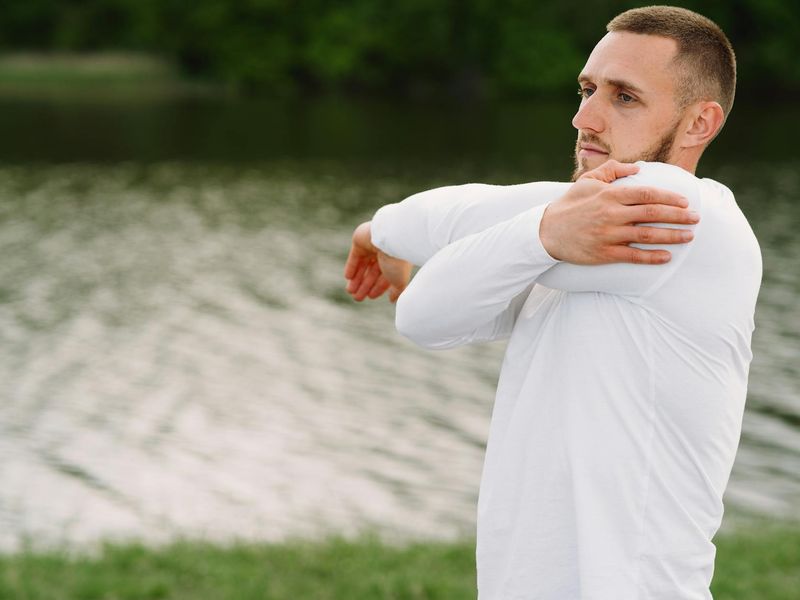 Man focused during a dynamic stretching routine.